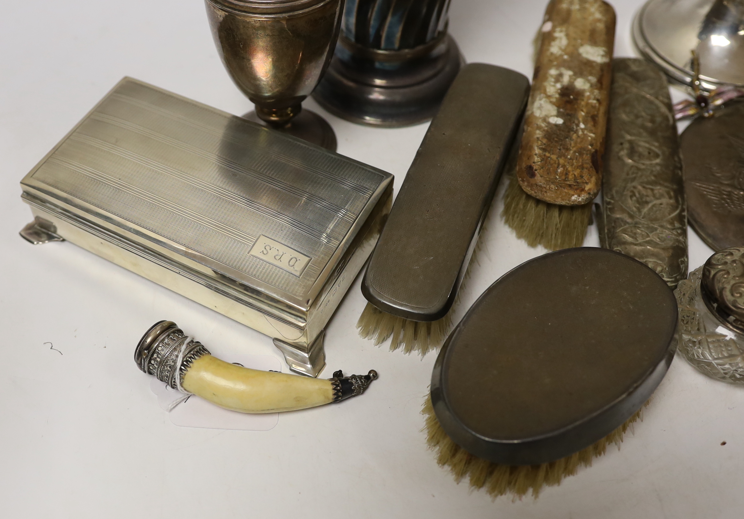 A group of sundry silver including an Edwardian demi-wrythened vase, London, 1901, 24.3cm, mounted hand mirror and three brushes, cigarette box, sugar caster and a damaged inkwell, together with a 1970's silver and ename